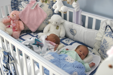 twins sleep together in same crib